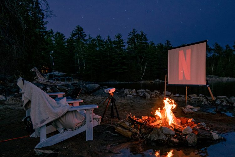 Movie screen outdoors with chairs in front